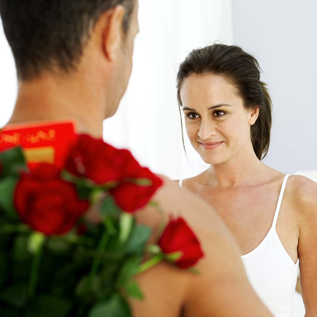 Young Man Hiding Red Roses Behind His Back